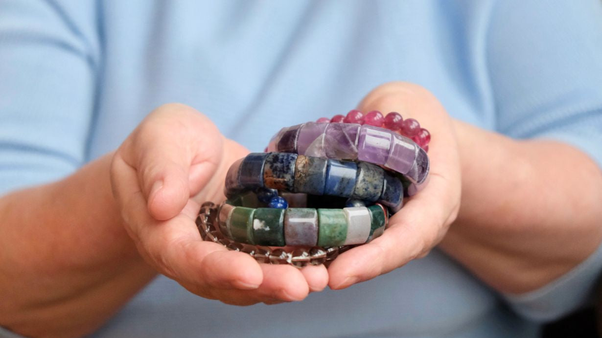 femme réfléchit dans quel poignet mètre ses bracelets en pierre naturelle pour la lithotherapie