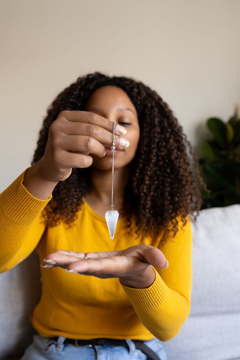 femme avec pendule en pierre naturelle radiesthesie